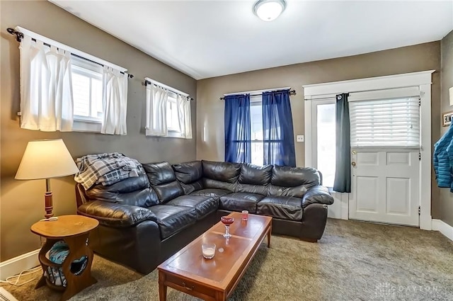 carpeted living area with baseboards