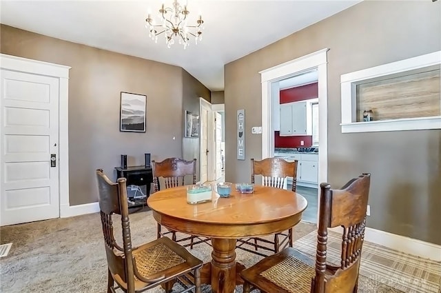 dining room featuring visible vents, baseboards, a notable chandelier, and light carpet