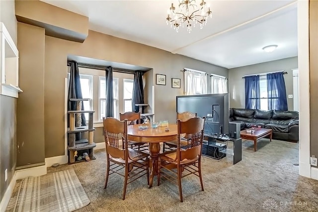 dining room featuring a notable chandelier, baseboards, and carpet