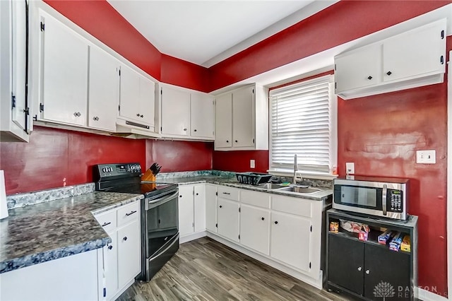 kitchen with electric range, dark wood-type flooring, white cabinets, under cabinet range hood, and stainless steel microwave