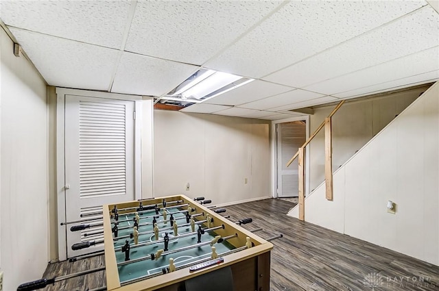 rec room with a paneled ceiling and wood finished floors