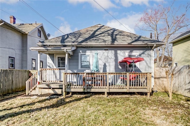 back of house featuring a wooden deck, a shingled roof, and fence