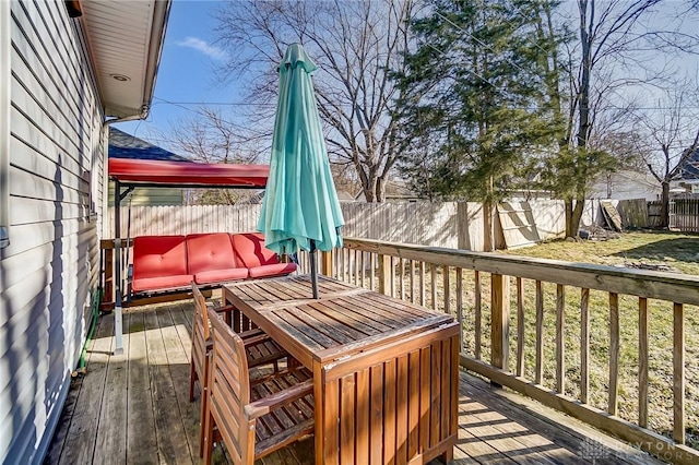 wooden deck featuring outdoor lounge area and a fenced backyard