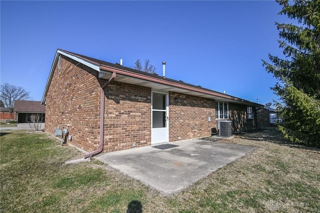 back of house with a patio area, brick siding, central AC, and a lawn