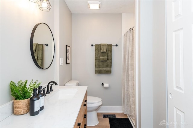 full bathroom featuring visible vents, toilet, wood finished floors, baseboards, and vanity