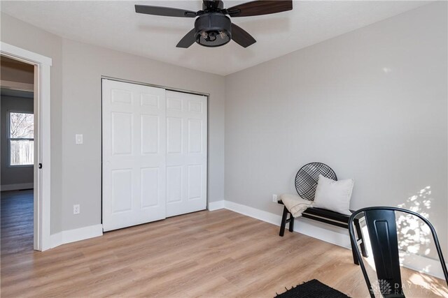 living area with light wood-type flooring and baseboards