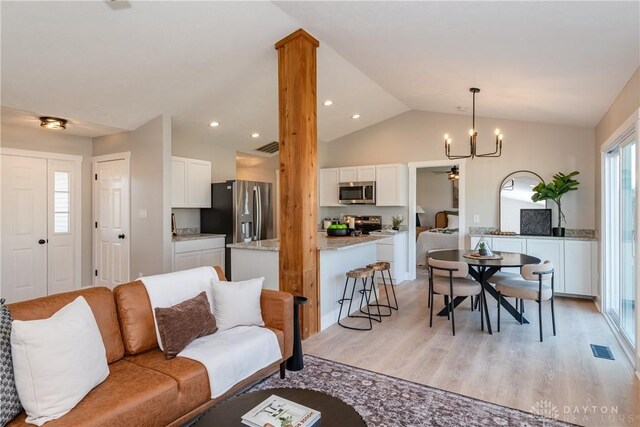 living room featuring light wood-type flooring, visible vents, a notable chandelier, recessed lighting, and vaulted ceiling