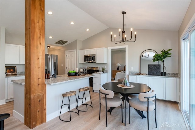 kitchen featuring white cabinetry, light stone counters, light wood-type flooring, and stainless steel appliances