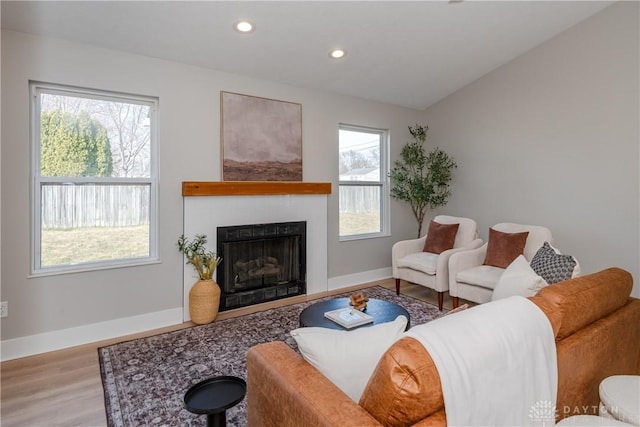 living room featuring wood finished floors, recessed lighting, a fireplace, baseboards, and vaulted ceiling