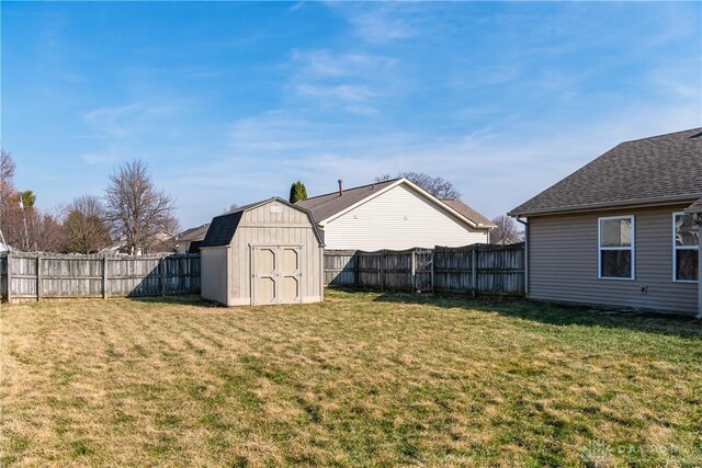 view of yard featuring a fenced backyard, a storage shed, and an outdoor structure