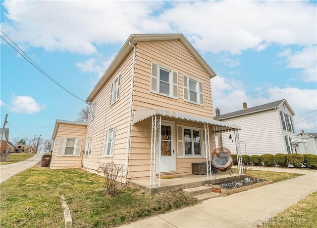 view of front of property with a patio and a front lawn