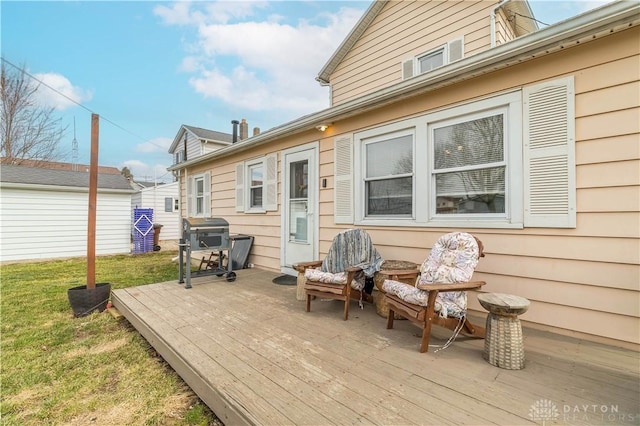 wooden deck with a lawn and a grill
