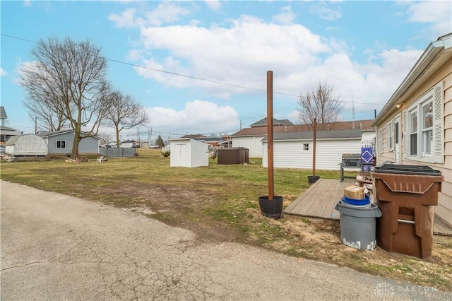 view of yard featuring a deck, an outdoor structure, and a shed