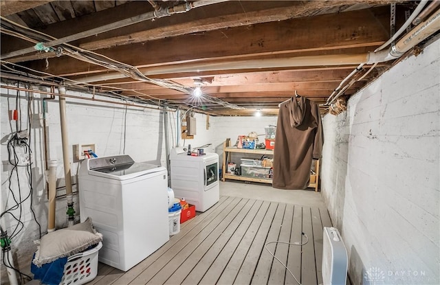 unfinished below grade area featuring electric panel and washing machine and clothes dryer