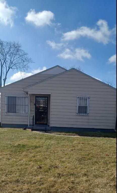 rear view of house featuring a lawn