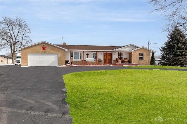 single story home with aphalt driveway, an attached garage, brick siding, and a front lawn