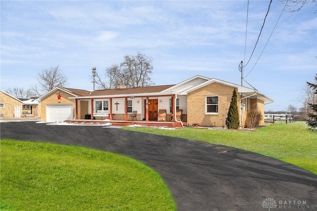 single story home with a front lawn, aphalt driveway, covered porch, an attached garage, and brick siding