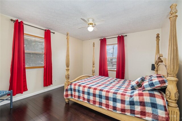 bedroom featuring baseboards, wood-type flooring, a textured ceiling, and a ceiling fan