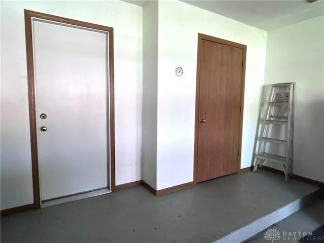 interior space with a closet, baseboards, and concrete floors