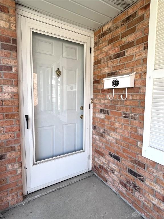 entrance to property featuring brick siding