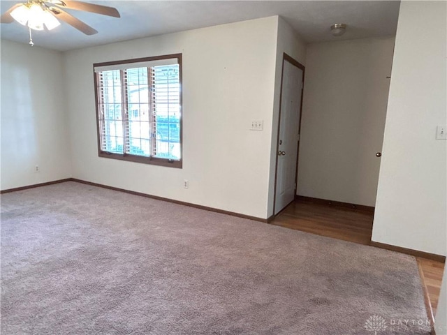 carpeted empty room with baseboards and ceiling fan