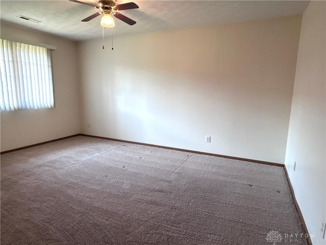 carpeted empty room featuring visible vents, ceiling fan, a textured ceiling, and baseboards