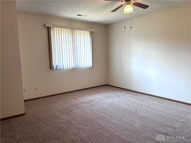 spare room featuring visible vents, baseboards, ceiling fan, a textured ceiling, and carpet flooring