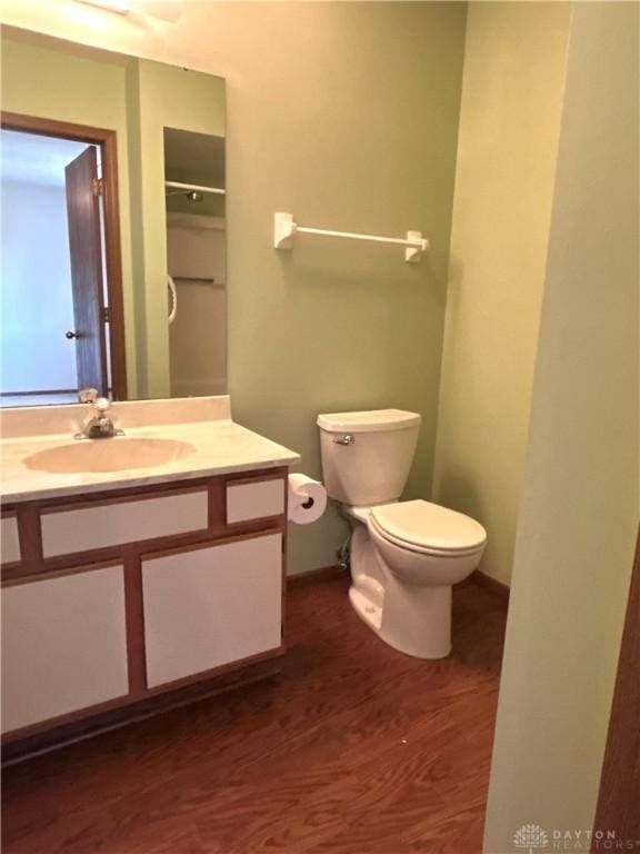 bathroom featuring toilet, vanity, and wood finished floors