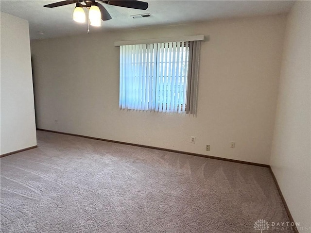 empty room featuring ceiling fan, carpet, visible vents, and baseboards