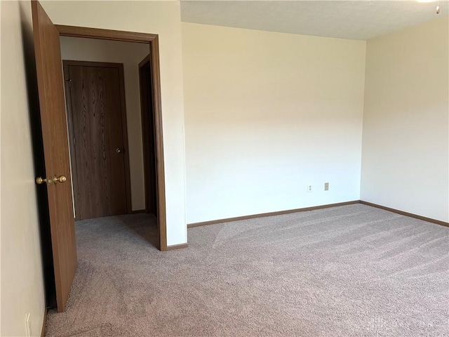 empty room featuring baseboards and carpet floors