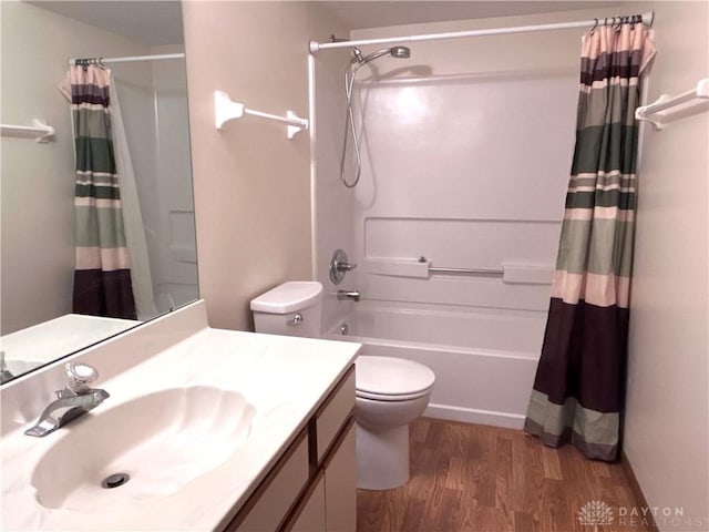 bathroom featuring vanity, toilet, wood finished floors, and shower / tub combo with curtain