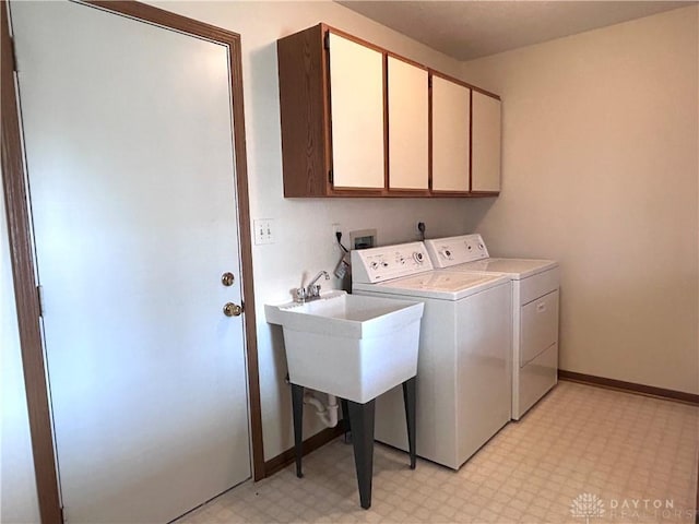 laundry area with cabinet space, baseboards, light floors, and washing machine and clothes dryer