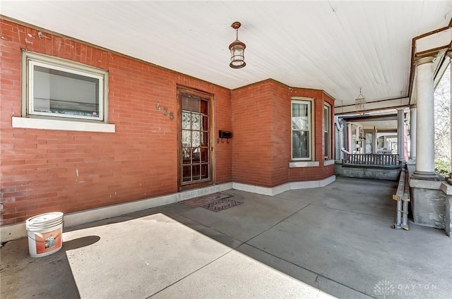 property entrance with brick siding and a porch