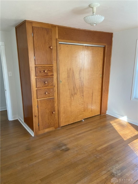 hall featuring baseboards and wood-type flooring