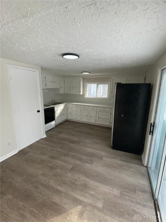 kitchen featuring dark wood-type flooring, light countertops, a textured ceiling, white cabinetry, and white range with electric stovetop