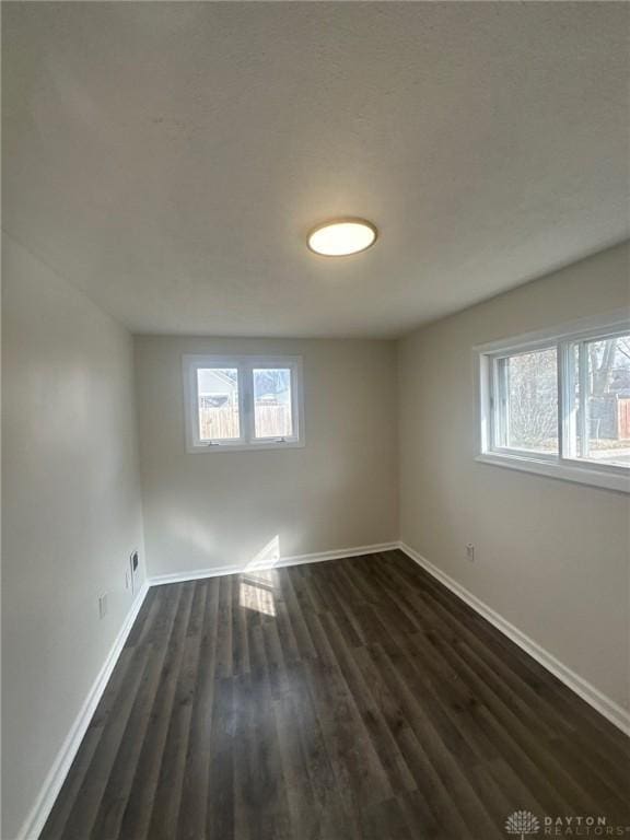 1297 Southlyn Dr, Dayton, OH 45409 - empty room with plenty of natural light, baseboards, and dark wood-style floors