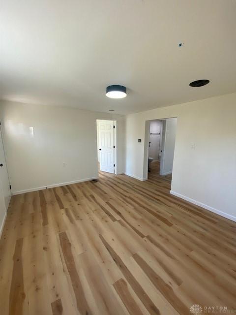 unfurnished room featuring baseboards and light wood finished floors