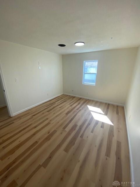 unfurnished room with light wood finished floors and baseboards