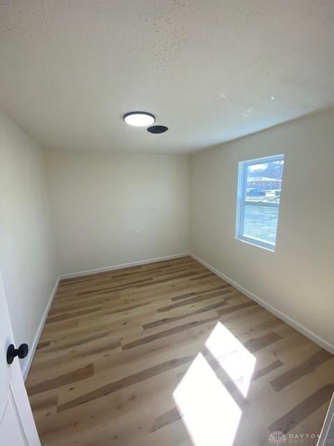 unfurnished room with baseboards and wood finished floors