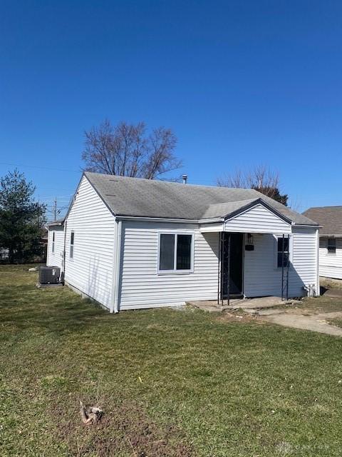 view of front of property with a front lawn and central air condition unit