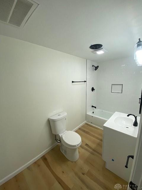 full bath featuring vanity, wood finished floors, visible vents, bathtub / shower combination, and toilet