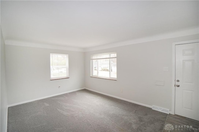 unfurnished room with carpet, baseboards, and visible vents