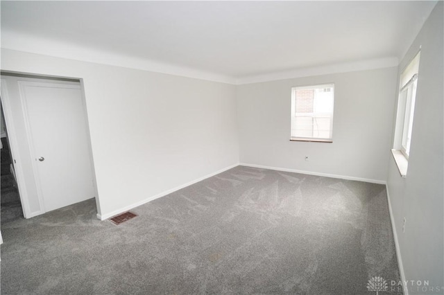 carpeted empty room with visible vents and baseboards