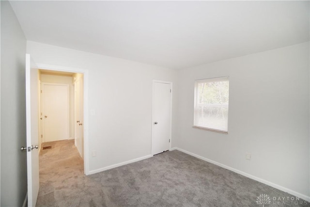 unfurnished bedroom with baseboards and carpet