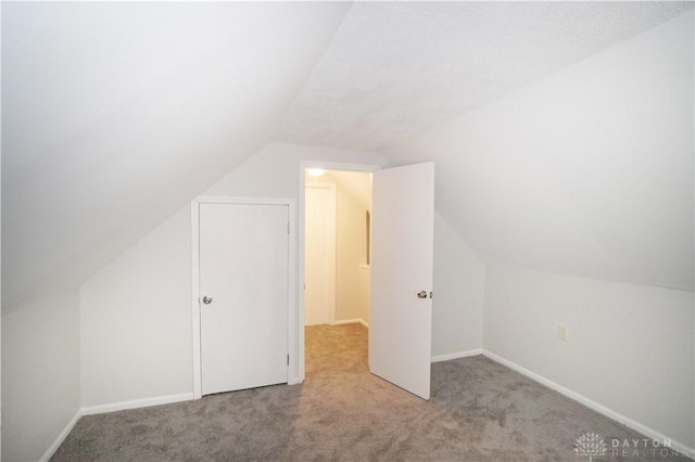 additional living space with lofted ceiling, carpet flooring, and baseboards