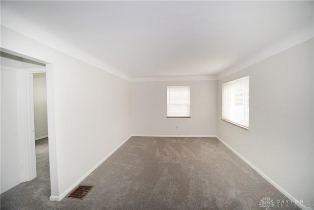 spare room featuring visible vents, baseboards, and carpet