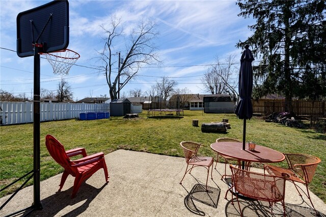 view of patio with a fenced backyard, a shed, an outdoor structure, and a trampoline