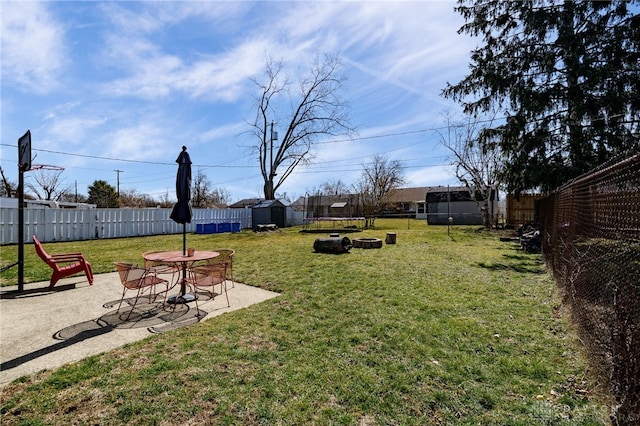 view of yard with a storage unit, a patio, an outdoor structure, and a fenced backyard