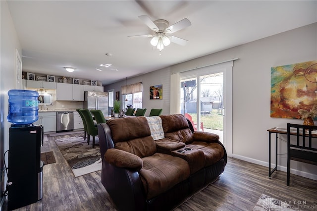 living area featuring dark wood-type flooring, a ceiling fan, and baseboards