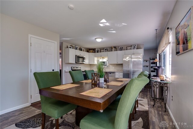 dining room with a wealth of natural light, dark wood-type flooring, and baseboards